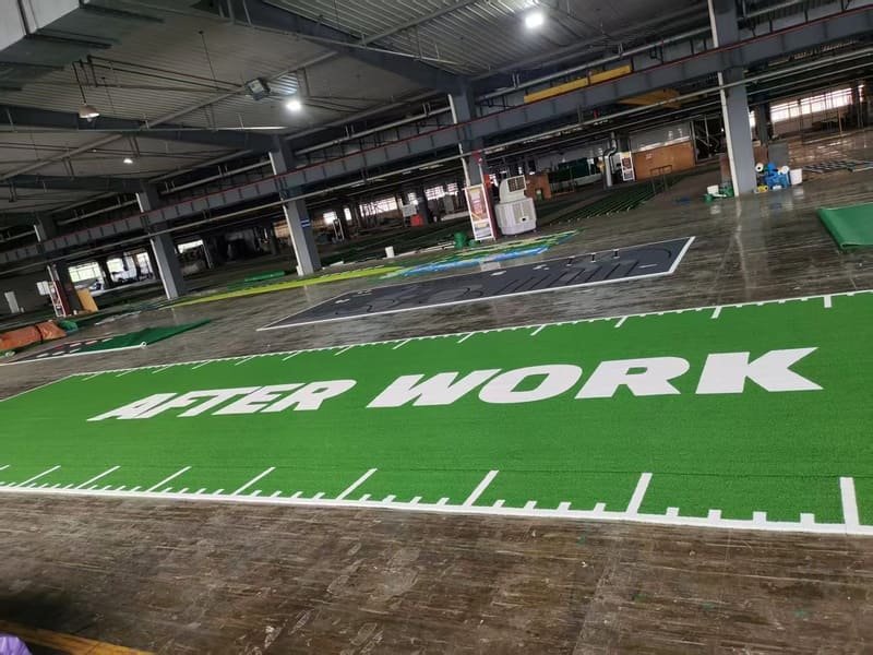 Close up of a weighted sled being pushed on a green high-density gym track